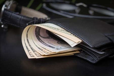 Dollar bills in a wallet and on a dark background.の写真素材