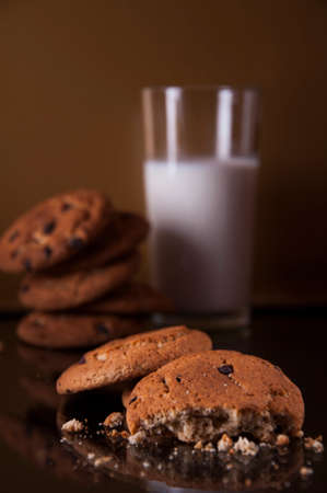 Oatmeal cookies with a glass of milk on a dark background.