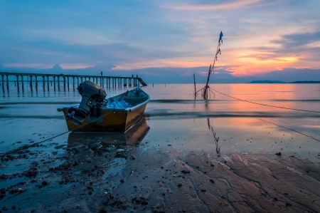 Small boat and a jetty at sunsetの写真素材
