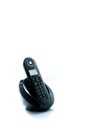 Wireless black telephone with cradle isolated on white background の写真素材