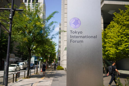 Tokyo, Japan - September 1st 2025 - Sign for the Tokyo International Forum on a silver plaque along a sunny, tree-lined city street.のeditorial素材