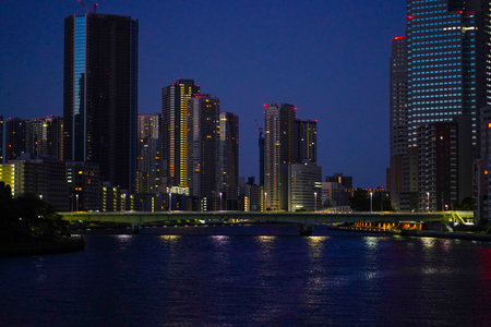 Tokyo, Japan - September 2, 2025 - Night view of a city skyline with illuminated skyscrapers...