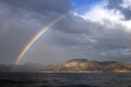 Rainbow over the sea and the islandの写真素材