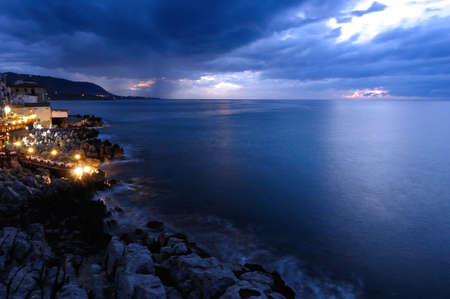 Sunset over the sea and old townの写真素材