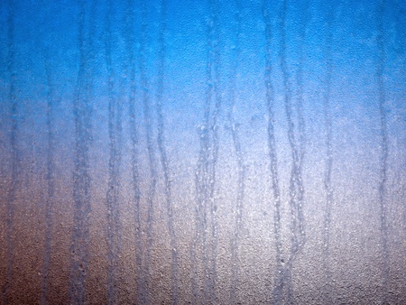 Frozen water on the glass in blue gray background