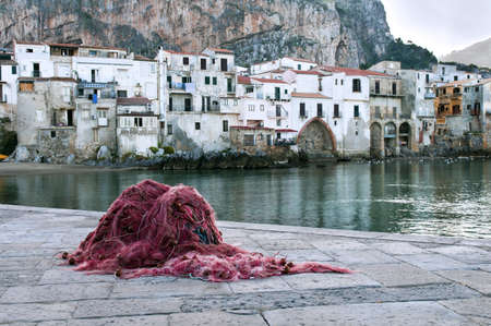Fishing net and old fishing town of Cefalu, Sicilyの写真素材