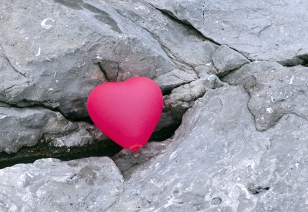 the pink inflatable balloon lying on the ground, the shape of the heart の写真素材