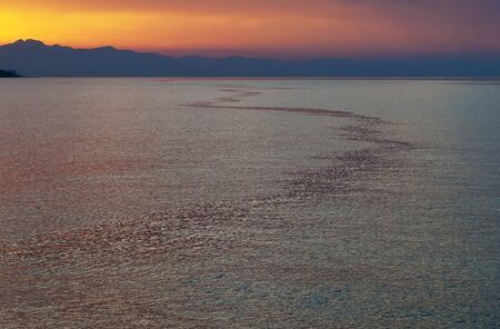 Sunset, silhouette of the mountains and the sea.の写真素材