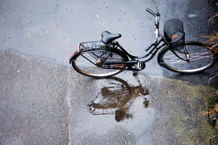 The bicycle standing on a street on a rainy dayの写真素材