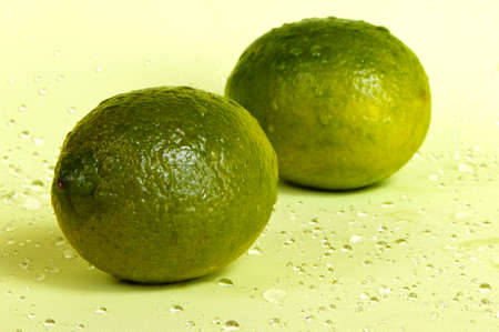 A closeup of two whole lime fruits