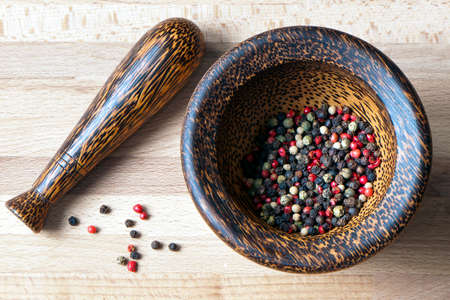Red, black, green and white peppercorns in a mortar