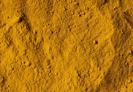 Deep-orange-yellow turmeric (curcuma) powder. View from above.の写真素材