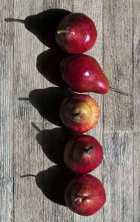 Five red pears in a line. View from aboveの写真素材