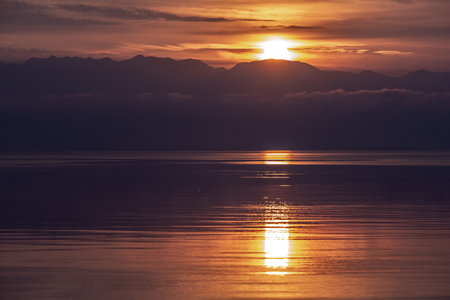 Landscape with mountains, sea, clouds and sunriseの写真素材