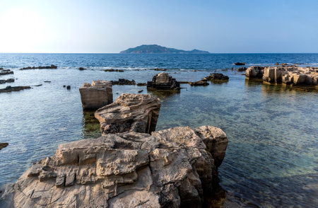 A landscape with a rocky coast in the evening with a view of another island, Italy, Sicily.の写真素材