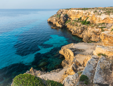 A landscape with a rocky coast and clear water in the evening. Italy, Sicilyの写真素材