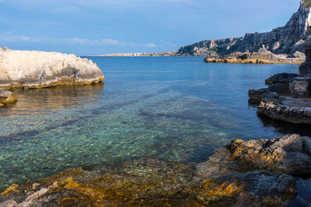 A landscape with a rocky coast and clear water in the evening. Italy, Sicilyの写真素材