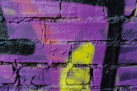 Old colorful paint with cracks on red brick wall as background, textureの写真素材