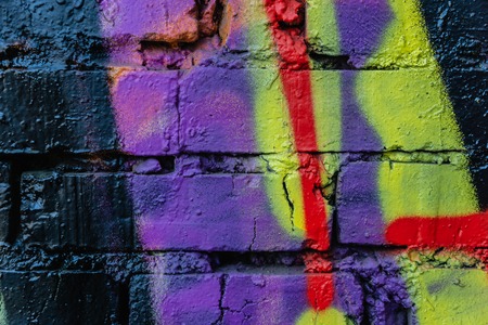 Old colorful paint with cracks on red brick wall as background, texture