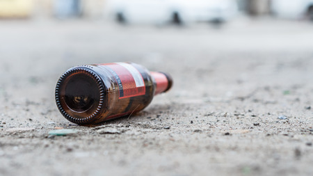 A glass bottle of beer littering on the street