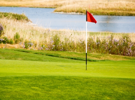 Flag of golf course with pond in backgroundの写真素材