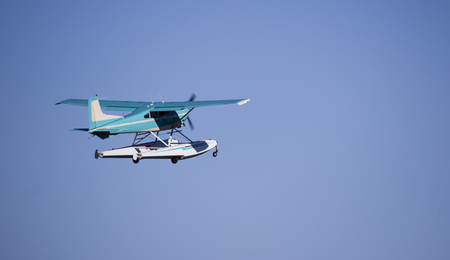 Turquoise sea plane taking off against blue skyの写真素材