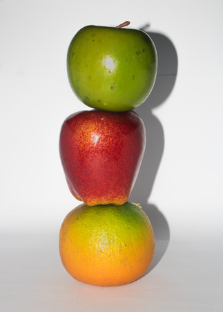 Vertical composition of three colorful fruits , isolated on white backgroundの写真素材