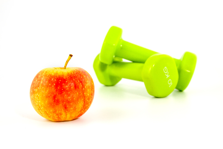 two dumbbells and the apple on a white backgroundの写真素材