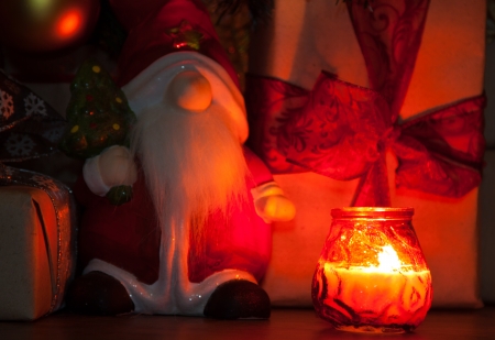 Santa with Christmas presents and a candleの写真素材