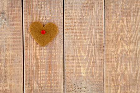 gingerbread heart hanging over wooden backgroundの写真素材