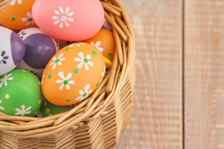 Easter eggs in basket on wooden backgroundの写真素材