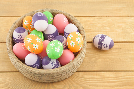 Easter eggs in basket on wooden backgroundの写真素材