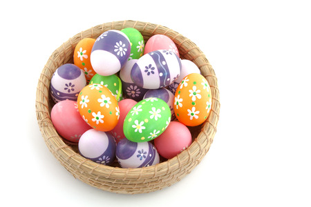 Easter eggs in basket isolated on white backgroundの写真素材