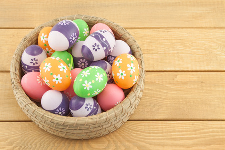 Easter eggs in basket on wooden backgroundの写真素材