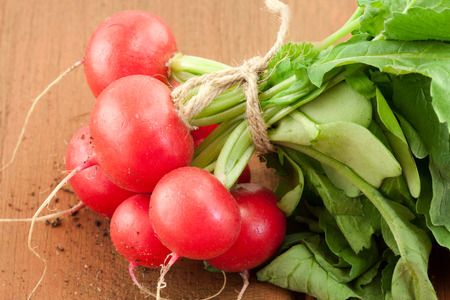 bunch of fresh red organic radish on wooden の写真素材