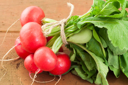 bunch of fresh red organic radish on wooden の写真素材