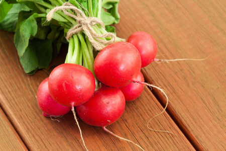 bunch of fresh red organic radish on wooden の写真素材