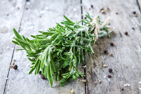 a bunch of fresh rosemary on a wooden backgroundの写真素材