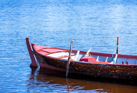 Old fishing wooden rowboat near the shoreの写真素材