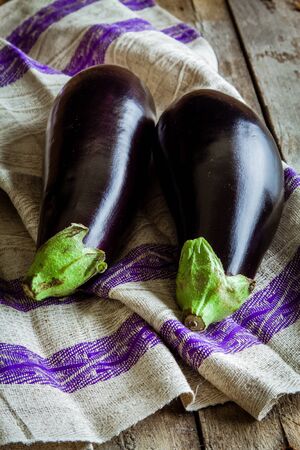 two raw organic eggplant on wooden backgroundの写真素材