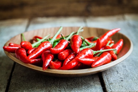 red hot chili peppers in the dish on wooden rustic backgroundの写真素材