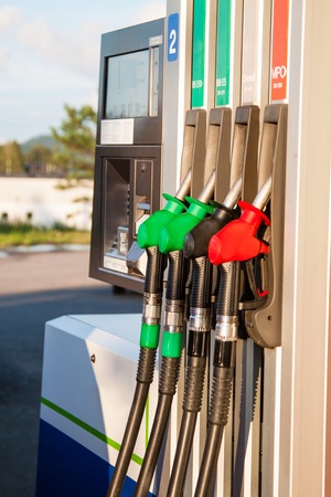 Red, green and black fuel pumps at petrol stationの写真素材