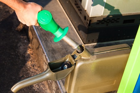 man filling canister with petrol at a gas stationの写真素材