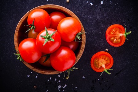 fresh organic cherry tomatoes in a bowl on a dark backgroundの写真素材