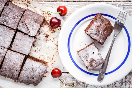 homemade chocolate brownie dessert pieces with cherries on a plateの写真素材