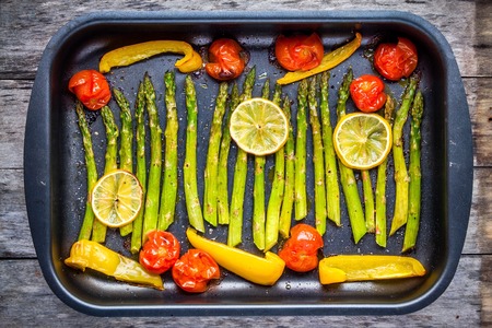 baked vegetables: asparagus, cherry tomatoespaprika, lemon in baking dishの写真素材