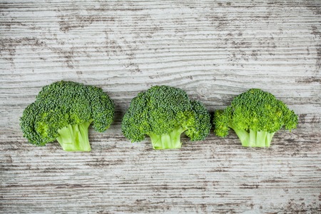 Fresh raw organic broccoli on a wooden background top viewの写真素材