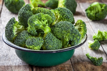 Fresh raw organic broccoli in bowl on wooden rustic backgroundの写真素材