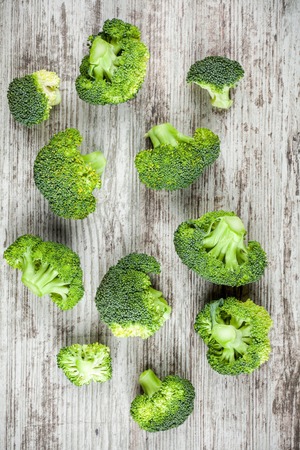 Fresh raw organic broccoli on a wooden background top viewの写真素材