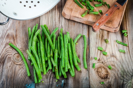 pods of fresh organic green beans on a rustic wooden tableの写真素材
